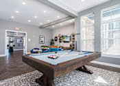 Thumbnail 4 of 24 - A pool table in a room with a view of the city.