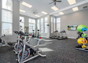 Thumbnail 5 of 24 - A gym with a row of stationary bikes and a treadmill.