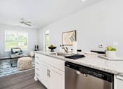 Thumbnail 13 of 24 - A modern kitchen with a stainless steel dishwasher and a ceiling fan.