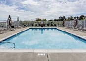 Thumbnail 20 of 22 - A large outdoor swimming pool surrounded by a metal fence.