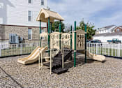 Thumbnail 21 of 22 - A playground with a slide and a wooden structure.