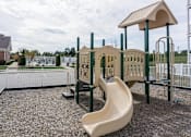 Thumbnail 22 of 22 - A playground with a yellow slide and a white fence.