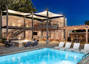 Thumbnail 38 of 46 - a swimming pool at a resort with a poolside bar and patio furniture