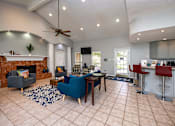 Thumbnail 21 of 30 - A living room with a fireplace and a blue chair.