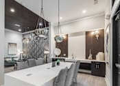 Thumbnail 23 of 41 - A modern dining room with a white table and grey chairs.