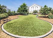 Thumbnail 33 of 41 - A grassy area with a white building in the background.