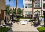Thumbnail 29 of 35 - a courtyard with three hammock chairs and a fire pit
