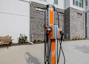 Thumbnail 33 of 47 - A charging station for electric vehicles is orange and black.