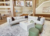 Thumbnail 20 of 36 - A white sofa with a green ottoman and a white coffee table in a spacious room.