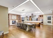 Thumbnail 22 of 36 - A modern kitchen with a dining table and chairs.