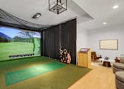 Thumbnail 30 of 36 - A room with a green mat on the floor and a screen on the wall.