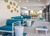 Thumbnail 15 of 29 - A white and blue living room with a white sofa and a white coffee table.