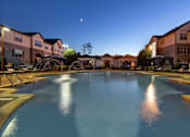 Thumbnail 22 of 24 - A large swimming pool surrounded by apartment buildings at dusk.