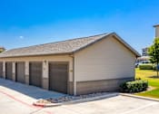 Thumbnail 16 of 18 - a small building with three garage doors on the side of a driveway
