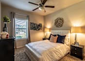 Thumbnail 4 of 18 - a bedroom with a large bed and a ceiling fan