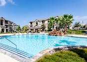 Thumbnail 1 of 18 - a large swimming pool with an apartment building in the background