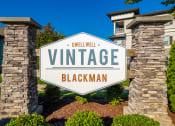 Thumbnail 33 of 37 - a sign that reads vintage with a building in the background