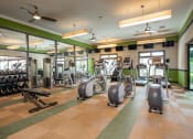Thumbnail 11 of 37 - a gym with treadmills and other exercise equipment in a building with green walls