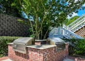 Thumbnail 23 of 27 - a brick barbecue with two bbq grills and a tree in the background at Crestmont at Thornblade, Greenville, SC, 29615