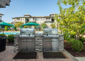 Thumbnail 15 of 37 - two stainless steel barbecue grills with umbrellas in the backyard of a house