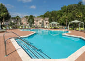 Thumbnail 1 of 18 - our apartments have a resort style pool with chairs and umbrellas