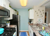 Thumbnail 8 of 18 - a kitchen with a stove and a refrigerator and a sink