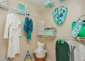 Thumbnail 16 of 18 - a closet with clothes and accessories hanging on the wall
