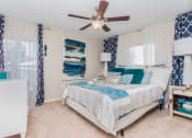 Thumbnail 12 of 18 - One, Two, and Three-Bedroom Apartments in Stockbridge, GA - Avenue 33 - Spacious Bedroom with Carpet Flooring, a Ceiling Fan, and Windows with Blinds.