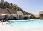 Thumbnail 1 of 16 - Atlanta, GA Apartments for Rent - City Park - Sparkling Swimming Pool with Sundeck, Umbrella Tables, Chairs, Lounge Seats, and View of Apartment Buildings.