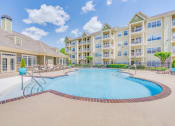 Thumbnail 2 of 29 - a swimming pool with an apartment building in the background