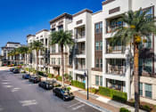 Thumbnail 34 of 35 - an apartment building with palm trees and cars parked in front of it