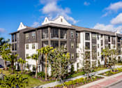 Thumbnail 27 of 29 - A large apartment complex with a red and white walkway in front.