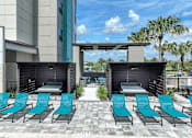 Thumbnail 43 of 54 - A row of blue lounge chairs are set up on a patio.