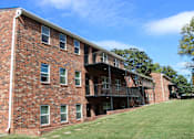 Thumbnail 22 of 24 - A red brick building with a balcony and stairs.