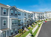 Thumbnail 1 of 14 - A row of modern townhouses with a car parked on the street.