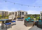 Thumbnail 40 of 49 - a rooftop patio with tables and chairs and a building in the background