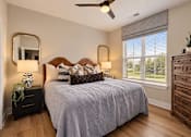 Thumbnail 4 of 29 - A bedroom with a bed, dresser, and mirror.