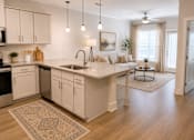 Thumbnail 16 of 35 - A kitchen with white cabinets and a rug on the floor.