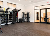 Thumbnail 20 of 35 - A gym with a variety of equipment including a squat rack, a leg press machine, and a bench.