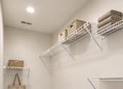 Thumbnail 14 of 35 - A white closet with a grey carpet and a white shelf.