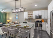 Thumbnail 23 of 46 - A modern kitchen with a dining table set for four.