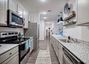 Thumbnail 20 of 31 - A modern kitchen with granite countertops and stainless steel appliances.