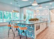 Thumbnail 3 of 31 - A kitchen with a blue and white patterned island and wooden bar stools.