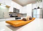 Thumbnail 11 of 22 - a kitchen with white cabinets and stainless steel appliances