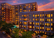Thumbnail 1 of 39 - A large apartment complex with a pool in the courtyard.