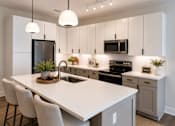 Thumbnail 4 of 5 - A modern kitchen with a white countertop and grey cabinets.