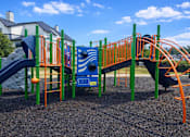 Thumbnail 13 of 20 - A playground with a blue slide and orange railings.