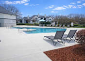 Thumbnail 7 of 20 - A pool with a few chairs around it.