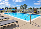 Thumbnail 16 of 22 - A pool surrounded by lounge chairs and umbrellas.