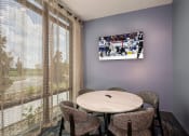 Thumbnail 12 of 47 - a dining room with a table and chairs and a tv on the wall